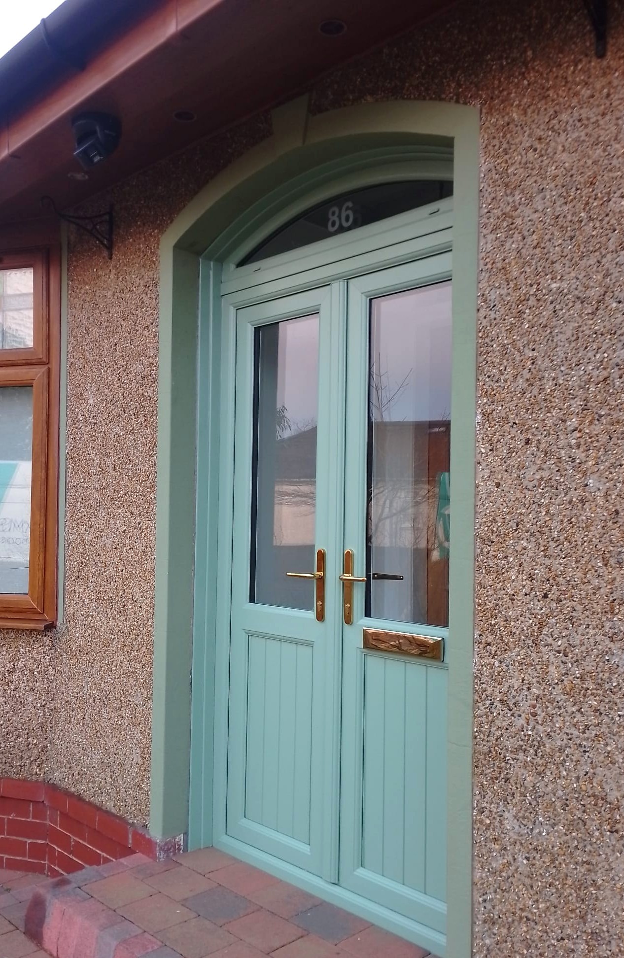 Chartwell green storm doors with shaped fan light
